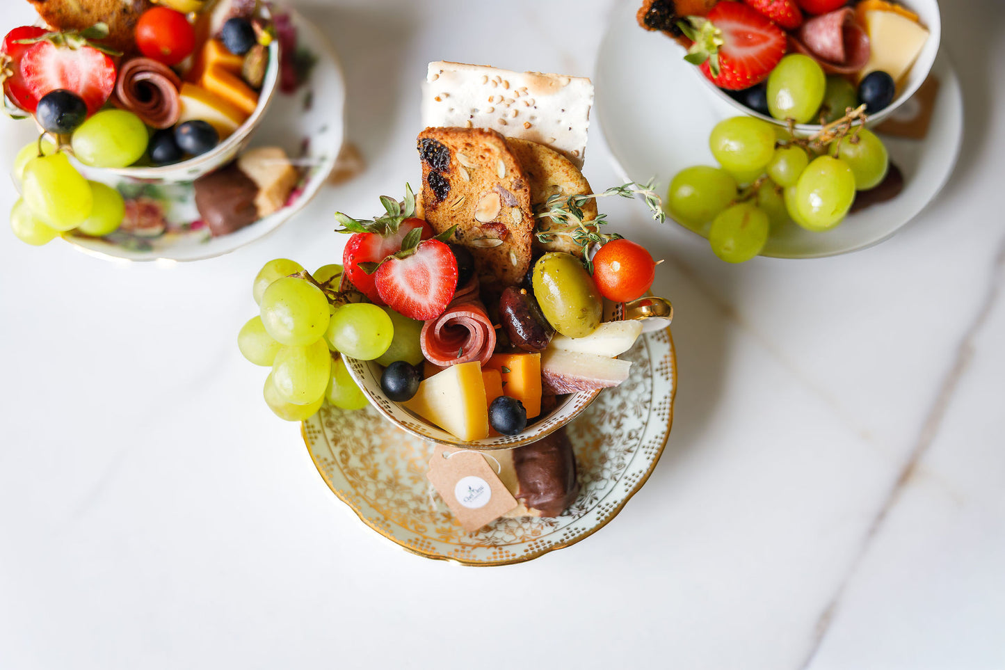 Collection of vintage teacup charcuterie cups arranged for weddings, bridal showers, corporate events, and elegant catered gatherings in Sioux Falls.